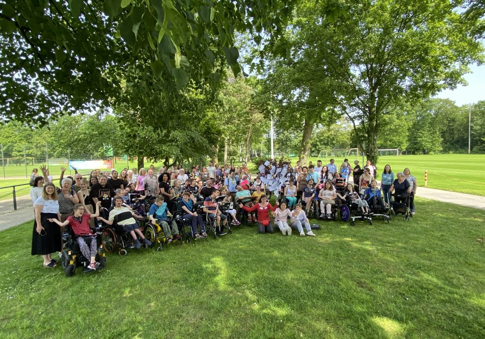 Gruppenbild mit den Teilnehmenden des UK-Jahrestreffens auf einer Wiese.